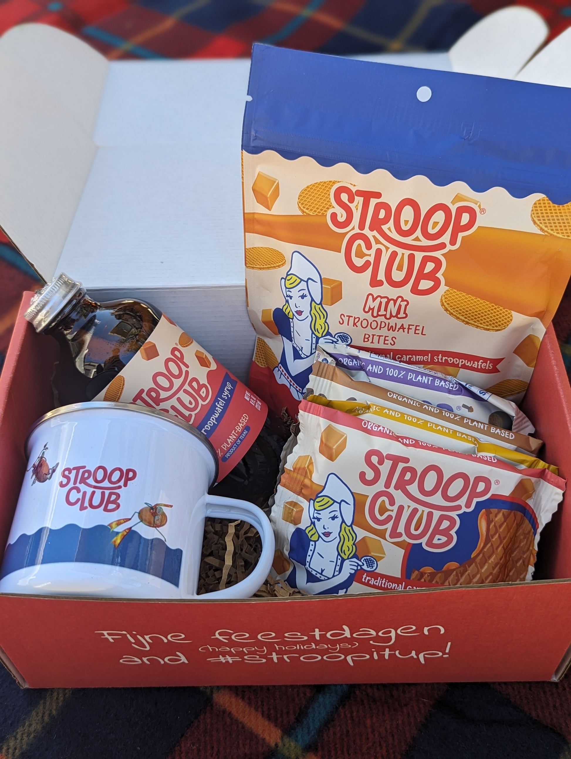 Photo of contents of giftbox showing 2-packs, a mug, syrup and a bag of stroopwafel minis